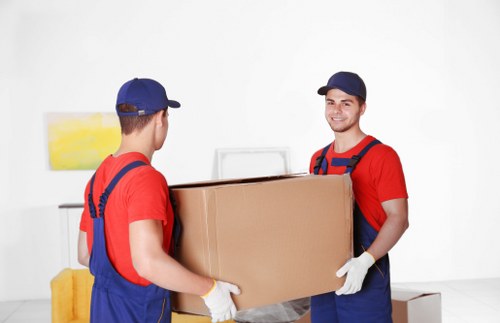 Professional house movers unloading items into an Acton property